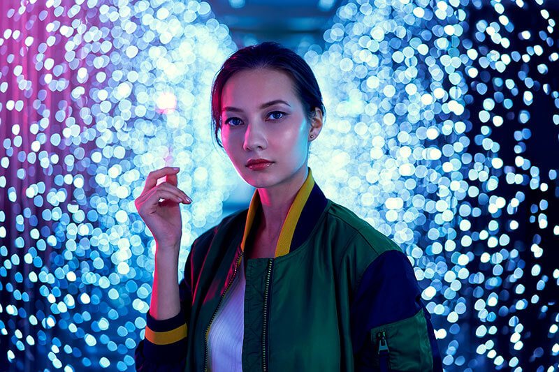 Portrait of model in front of lit background, demonstrating bokeh