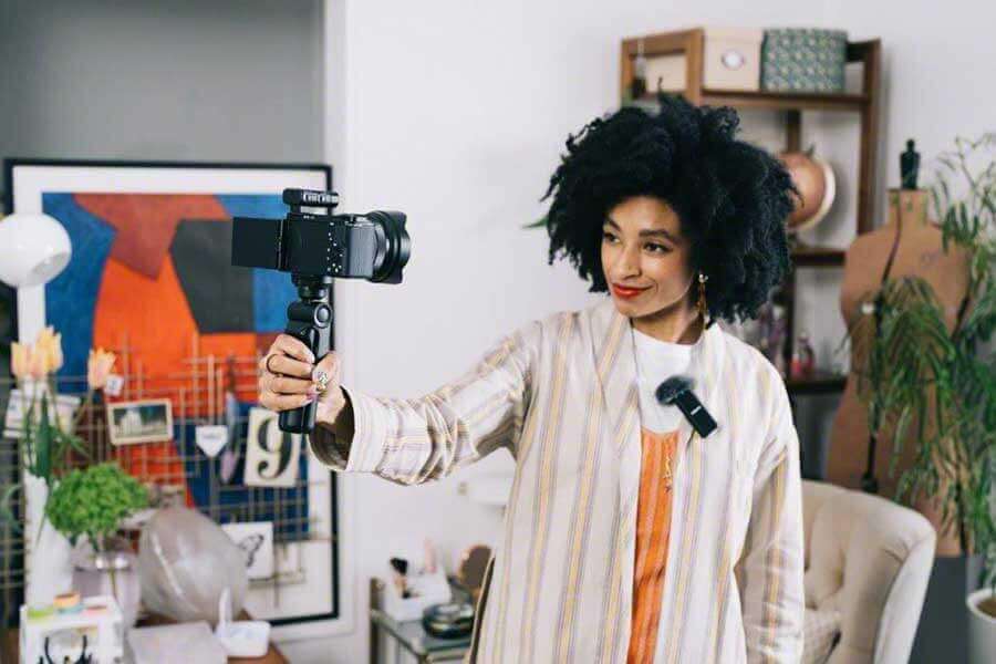Vlogger using ZV-E10 on shooting grip