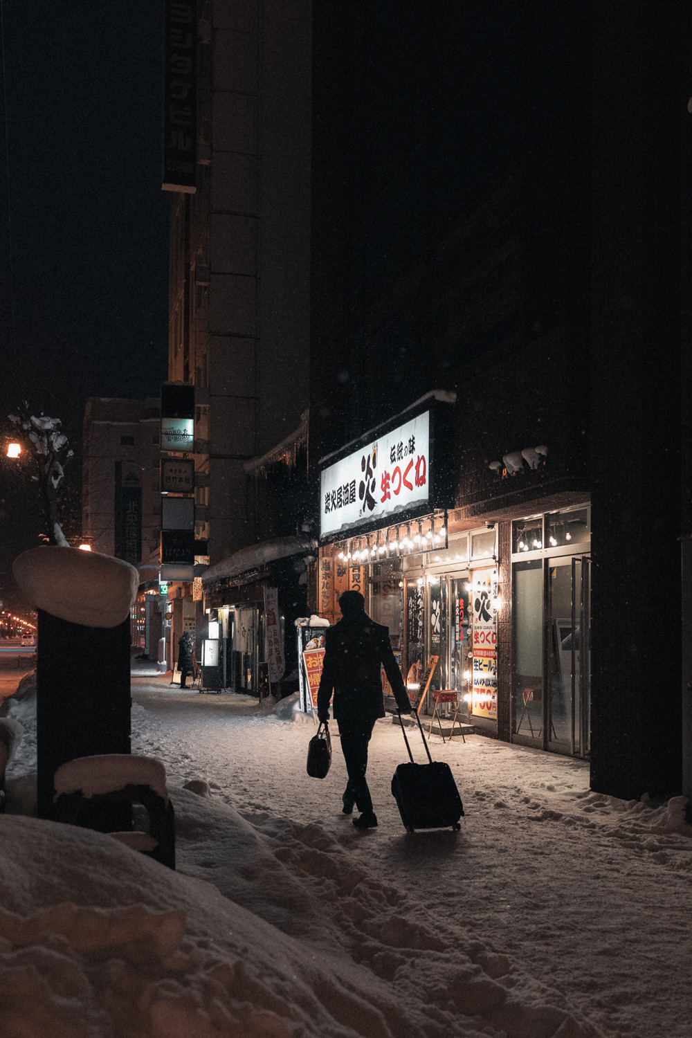 Street Photography - Walking down a snowy footpath with suitcase